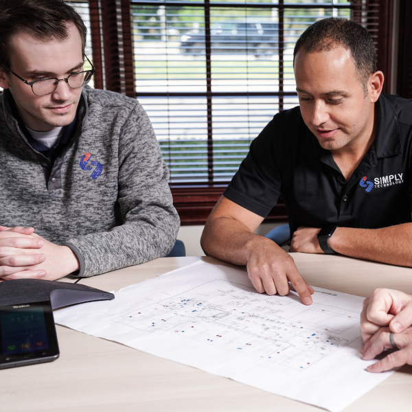 Simply Technology team reviewing network blueprints to plan smarter IT solutions.