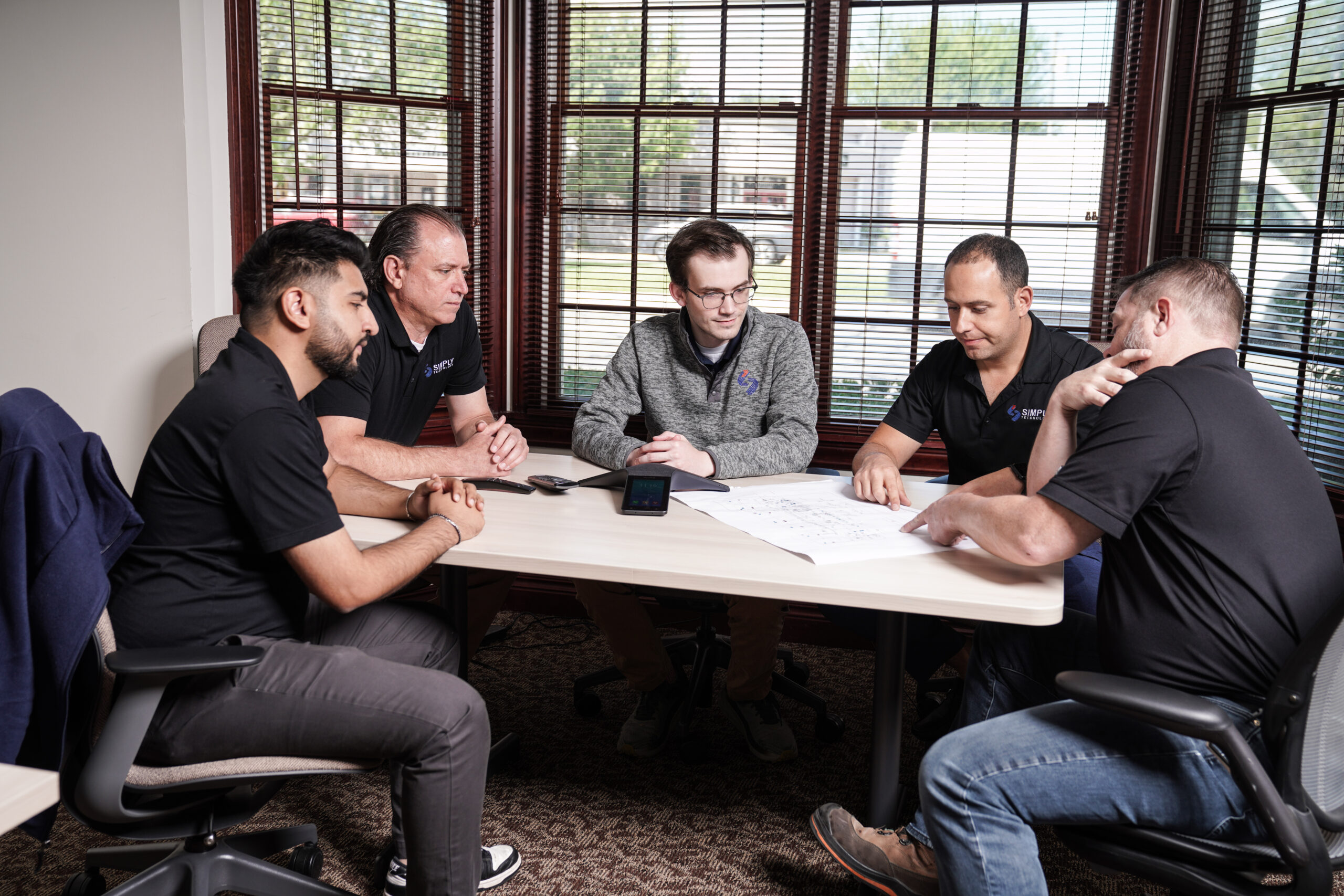 The Simply Technology team reviewing a network plan together at their Metro Detroit office